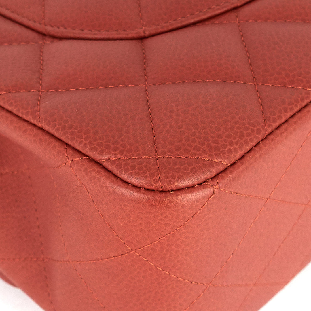 Close-up of a red quilted handbag with a white background