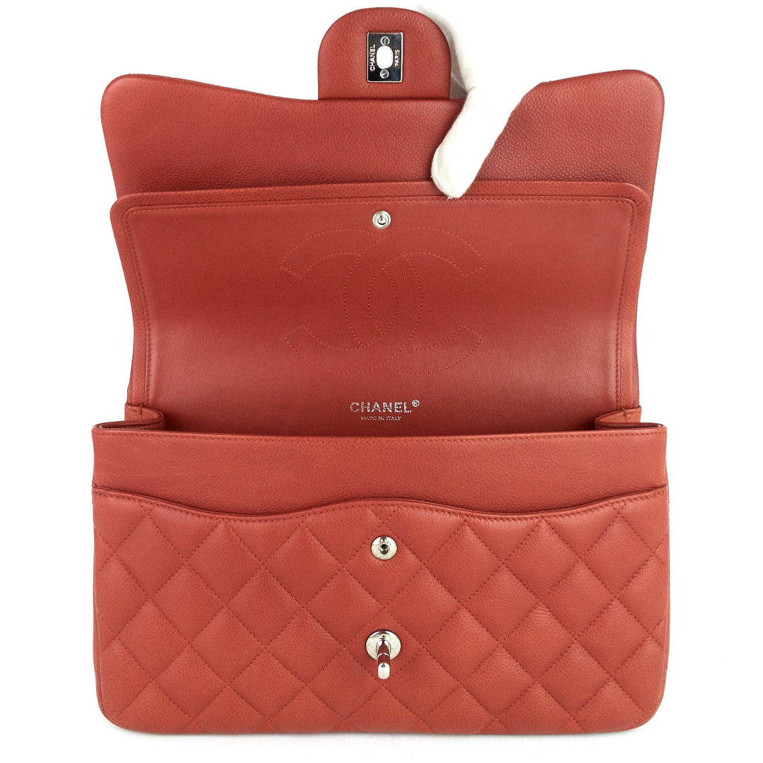 Open red leather Chanel handbag on a white background