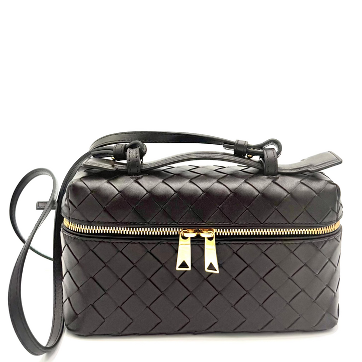 Black woven handbag with gold zipper on a white background