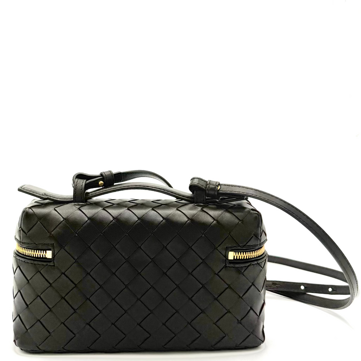 Black woven handbag with gold zipper on a white background