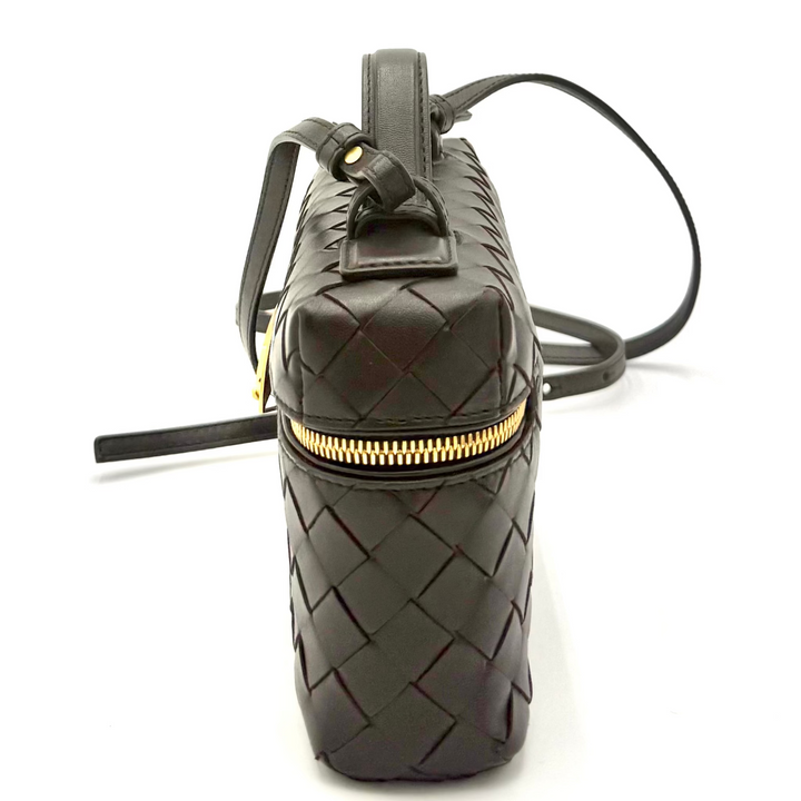 Black textured handbag with gold zipper on a white background