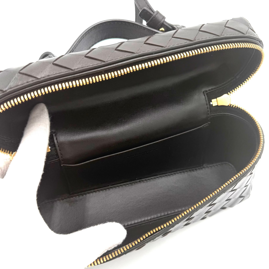 Black leather handbag with gold zipper on a white background