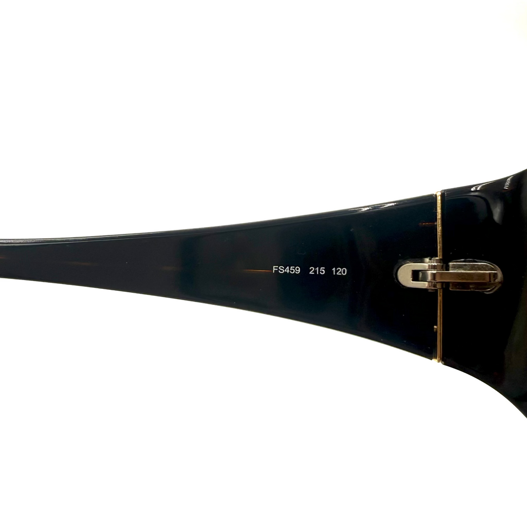 Close-up of the temple arm of a pair of sunglasses, showing a glossy black acetate frame with white printed size text 'FS459 215 120' and a gold metal hinge on a white background.