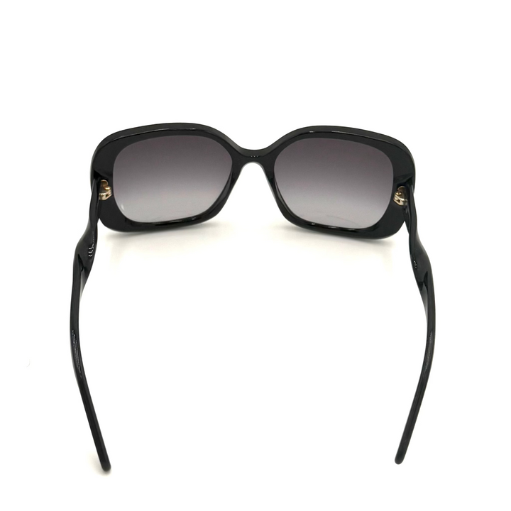 Black square sunglasses with gradient gray lenses and small gold metal accents on the temples, shown from the back on a white background.