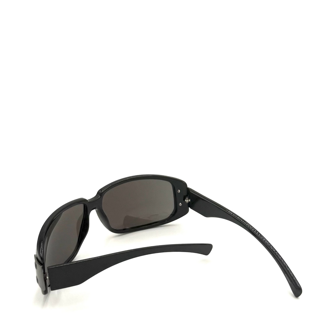 Black wrap-around sunglasses with dark tinted lenses, shown from a side angle on a plain white background.