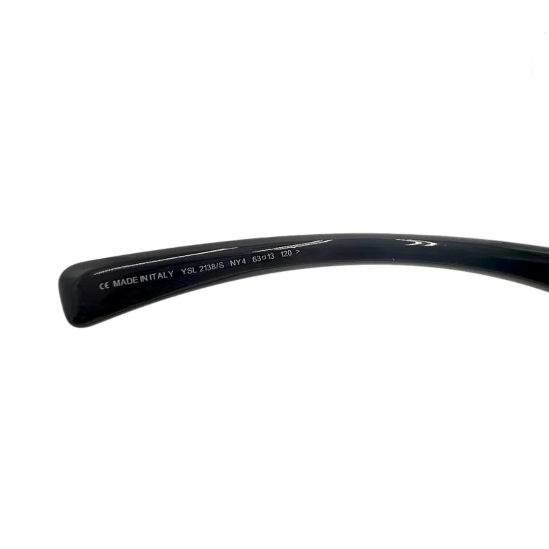 Close-up of a black acetate eyeglass arm showing printed white text including 'CE MADE IN ITALY' and model details, on a plain white background.
