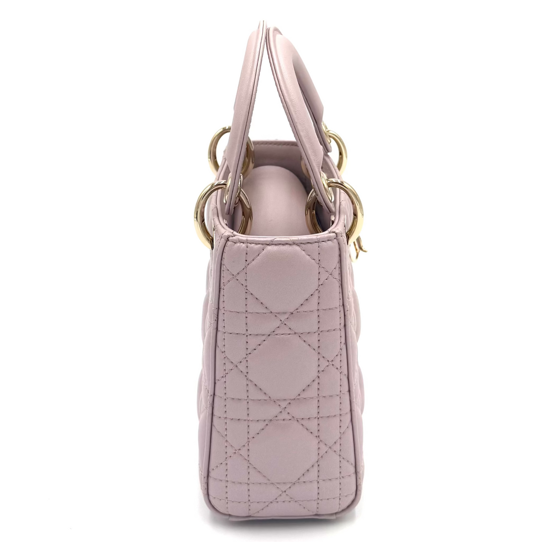 A light pink quilted leather handbag with gold-tone hardware, shown from a side profile view against a plain white background.