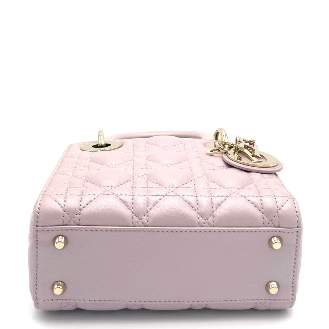 A light pink quilted leather handbag with gold-tone hardware, shown from a front-facing angle on a white background.