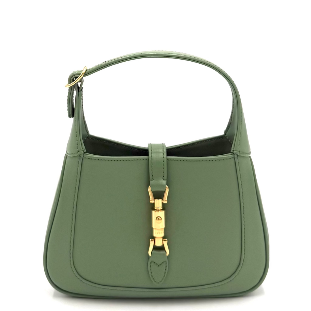 An olive green leather handbag with a top handle and a gold-tone turn-lock clasp on the front, shown against a plain white background.
