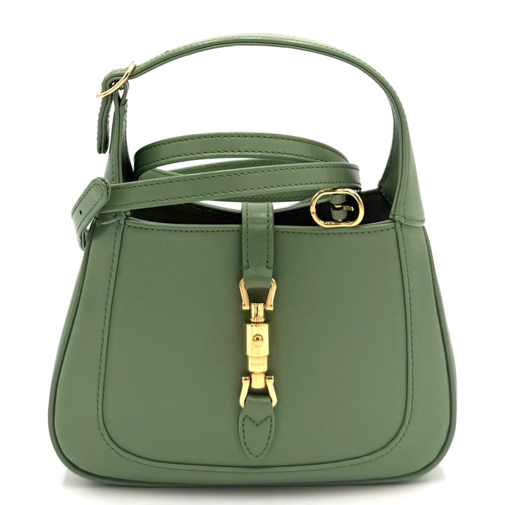 An olive green leather handbag with gold-tone hardware and a top handle, photographed against a white studio backdrop.