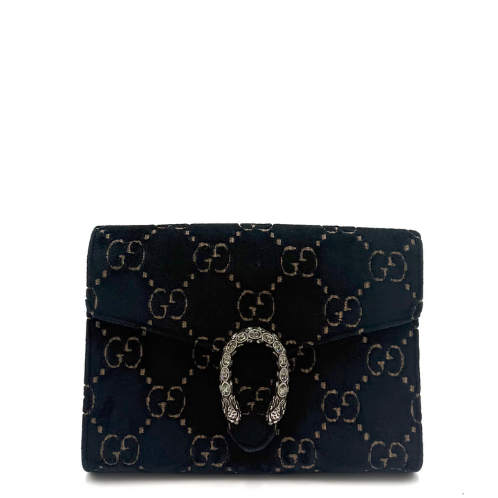 A small Gucci monogram wallet in dark navy velvet with gold-tone GG patterning and a silver-tone horsebit clasp, photographed on a white background.