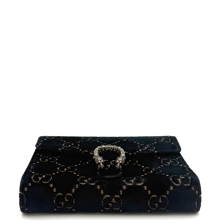 A black velvet clutch bag featuring the gold-tone interlocking GG monogram pattern and a central horsebit ring clasp, set against a plain white background.