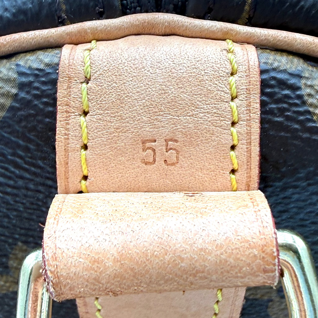 Close-up of a light tan leather strap with yellow contrast stitching, a stamped '55' on the center, and a metal buckle.