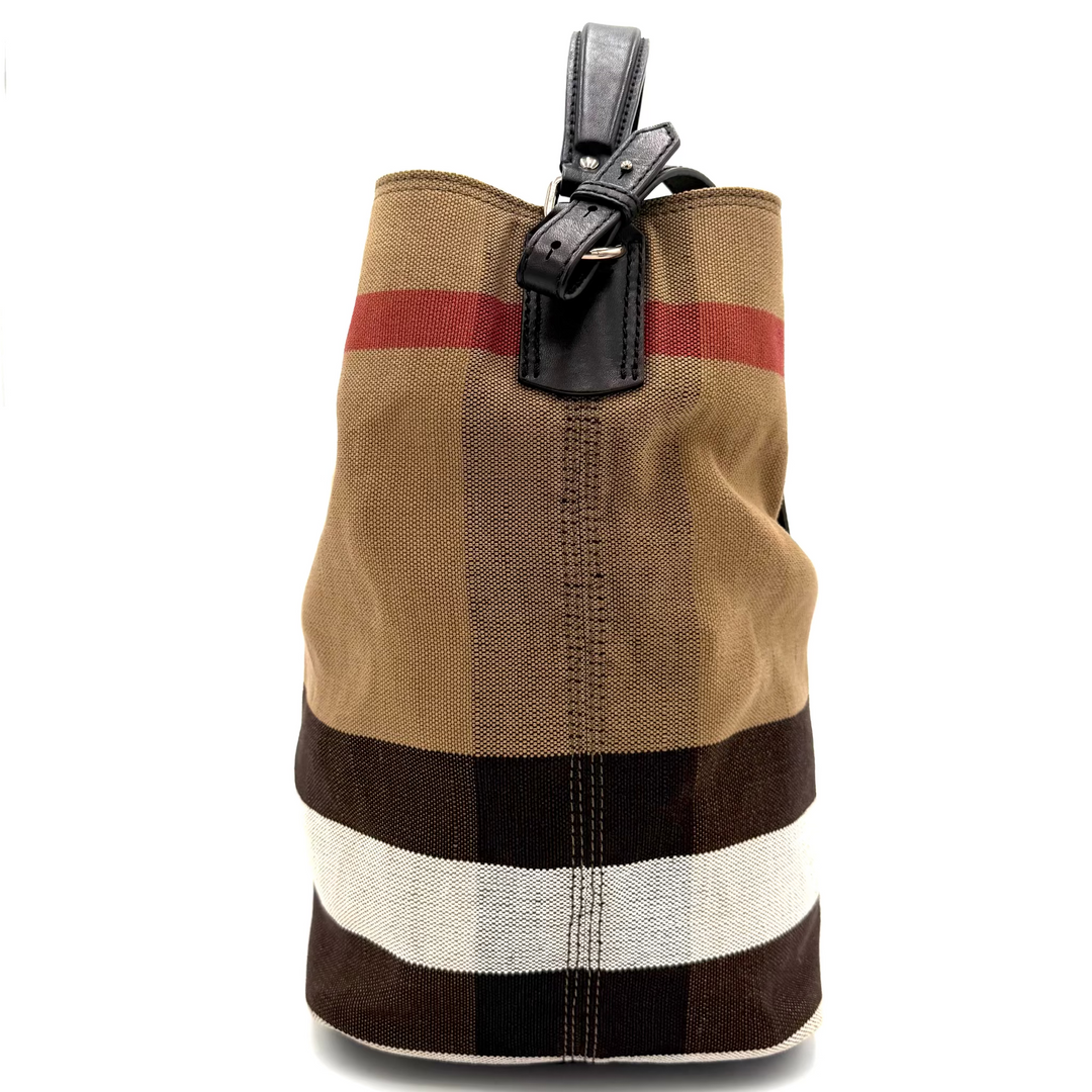 A vintage-style canvas bucket bag featuring the classic check pattern in beige, brown, black, and white, with a red stripe and a black leather top handle.