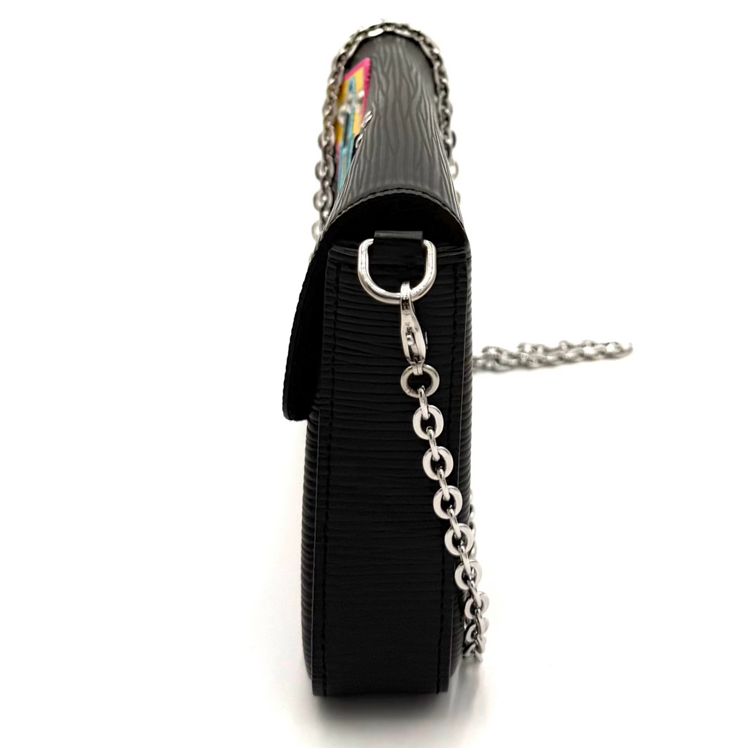 A black leather shoulder bag with a silver chain strap, shown from a side profile view on a plain white background.