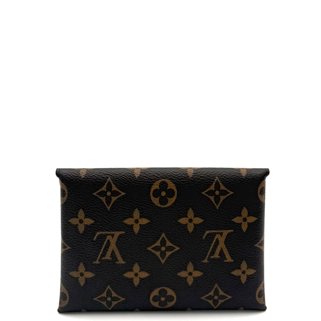 A Louis Vuitton monogram canvas pouch in black and brown, shown against a plain white background with a studio light visible on the right side.