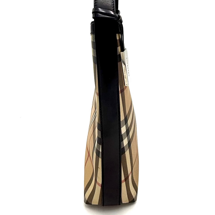 A vintage Burberry check shoulder bag with black leather trim and strap, photographed inside a lightbox studio setup. A hand with gold bracelets is visible holding the top edge of the lightbox.