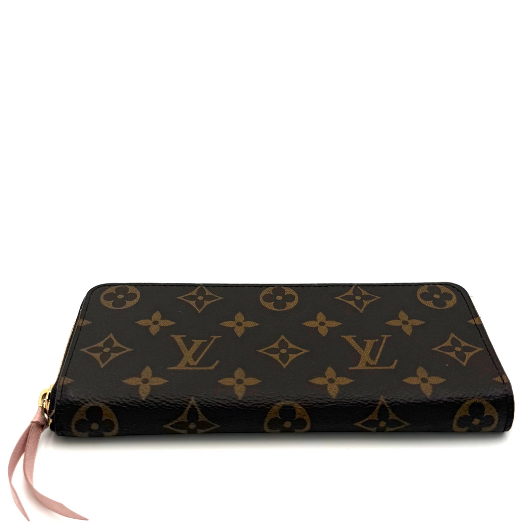 A Louis Vuitton monogram wallet in brown coated canvas with gold-tone hardware and a pink ribbon pull, shown on a plain white background.