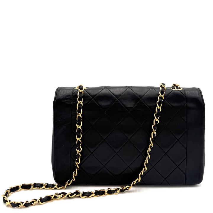A black quilted leather handbag with a gold chain strap, displayed against a clean white background.