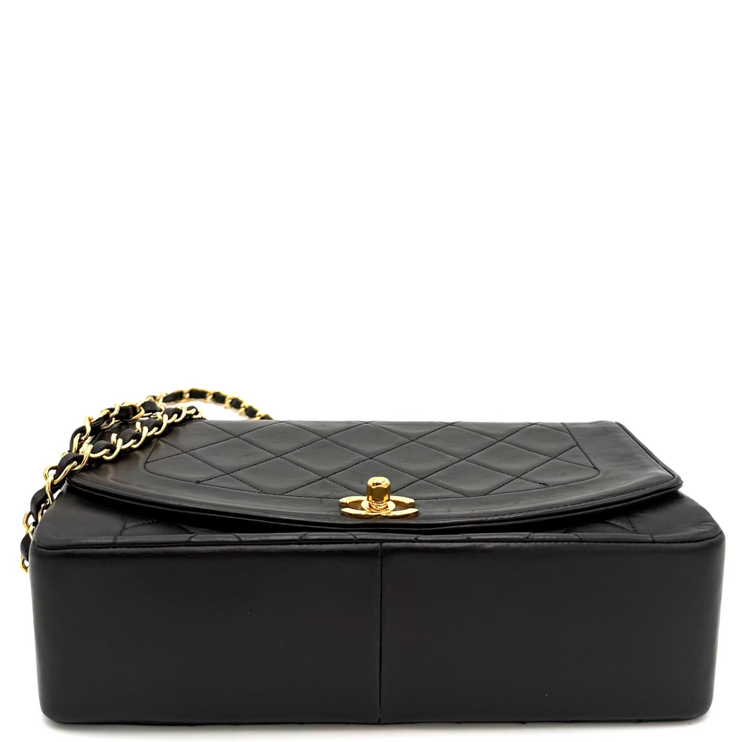 A black quilted leather handbag with a structured rectangular body, a gold-tone interlocking CC turn-lock closure, and a gold chain strap, shown on a white background.