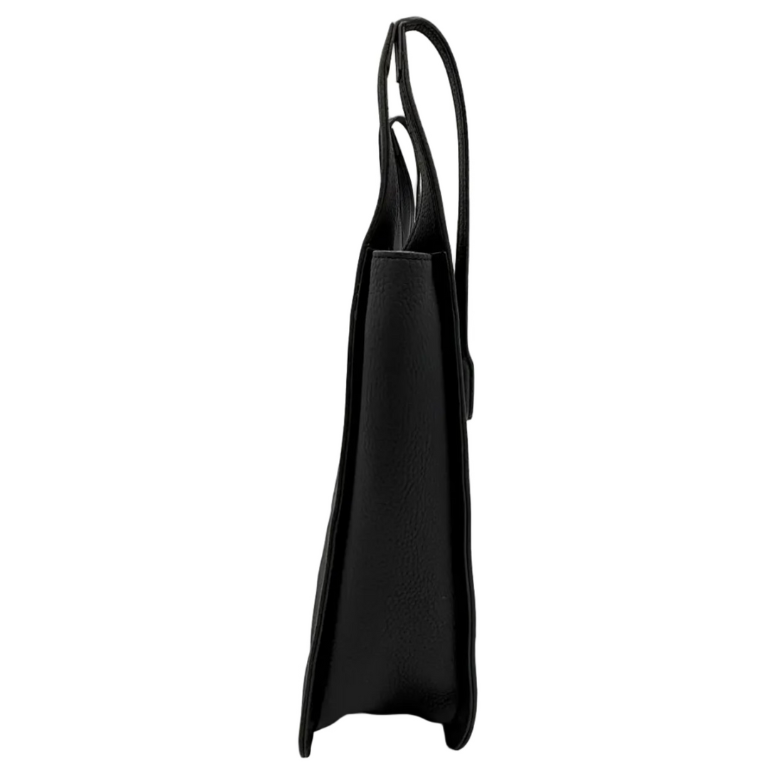 A black leather tote bag with a single shoulder strap, shown from the side profile inside a white lightbox studio setup.