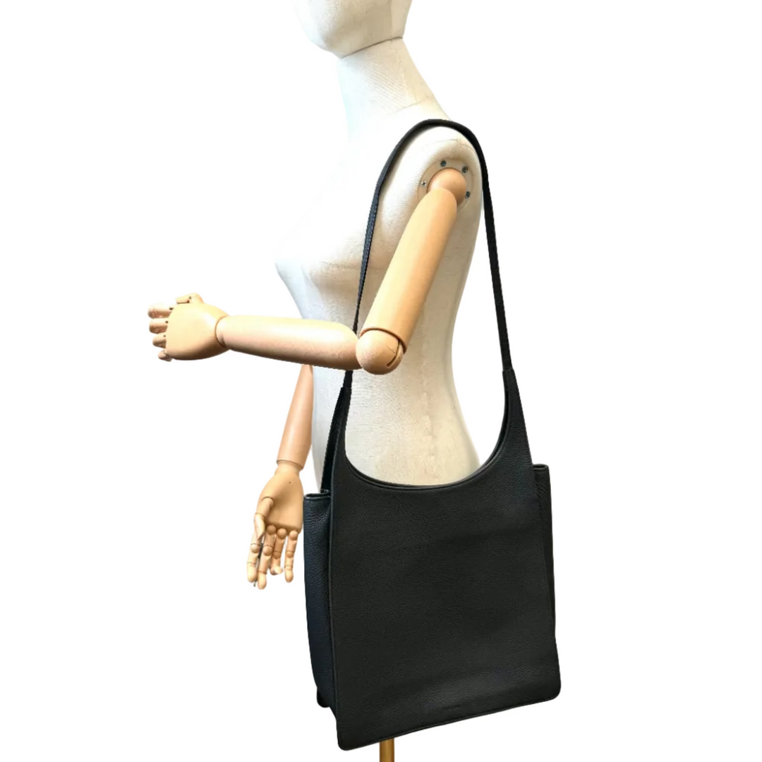 A black leather hobo shoulder bag with a single strap, displayed on a mannequin torso with articulated wooden arms against a plain white background.