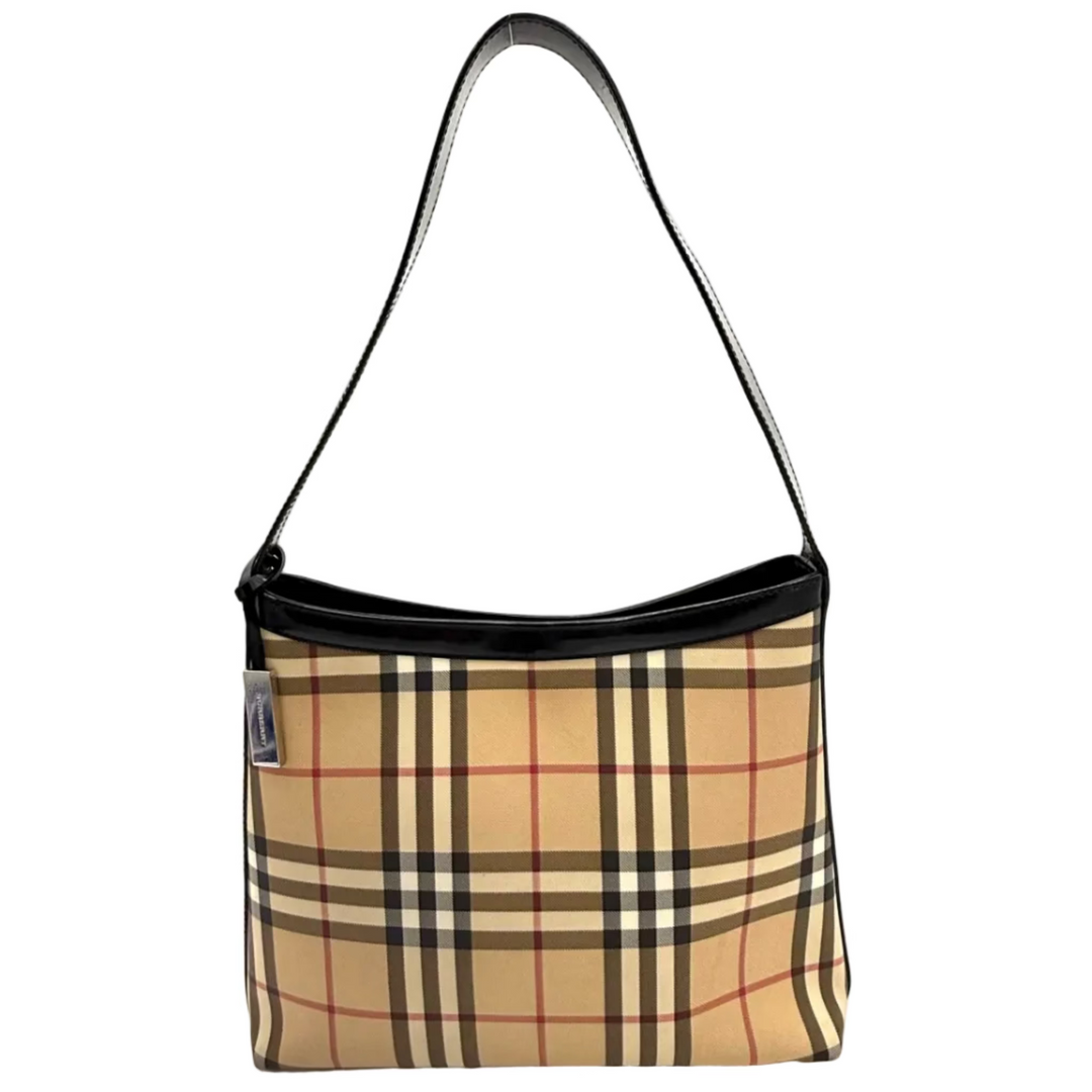 A beige plaid shoulder bag with black trim and a black strap, suspended by a hand inside a white light box.