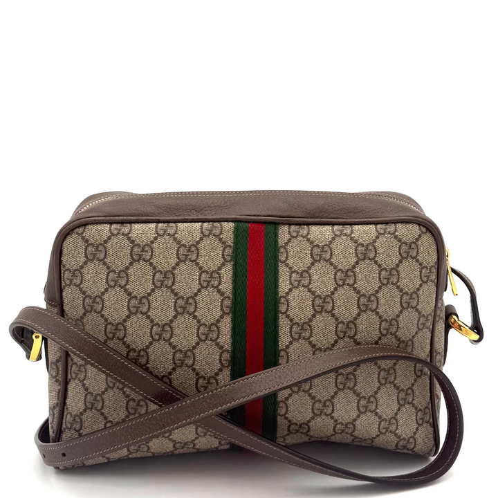 A Gucci GG Supreme crossbody bag in beige and brown with the signature green and red web stripe, shown on a white background.