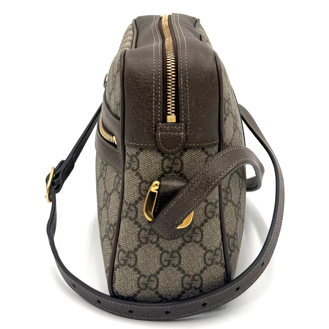 A Gucci shoulder bag in brown GG Supreme canvas with dark brown leather trim and gold-tone hardware, shown from the back on a white studio background.