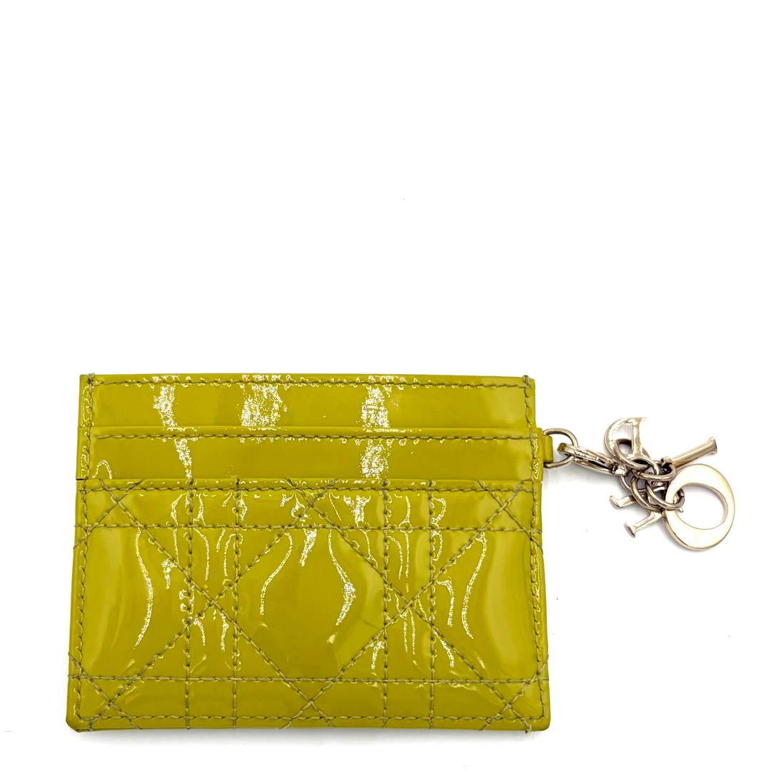 A lime green patent leather card holder with an embossed pattern and a silver-tone keychain attachment, shown on a plain white background.